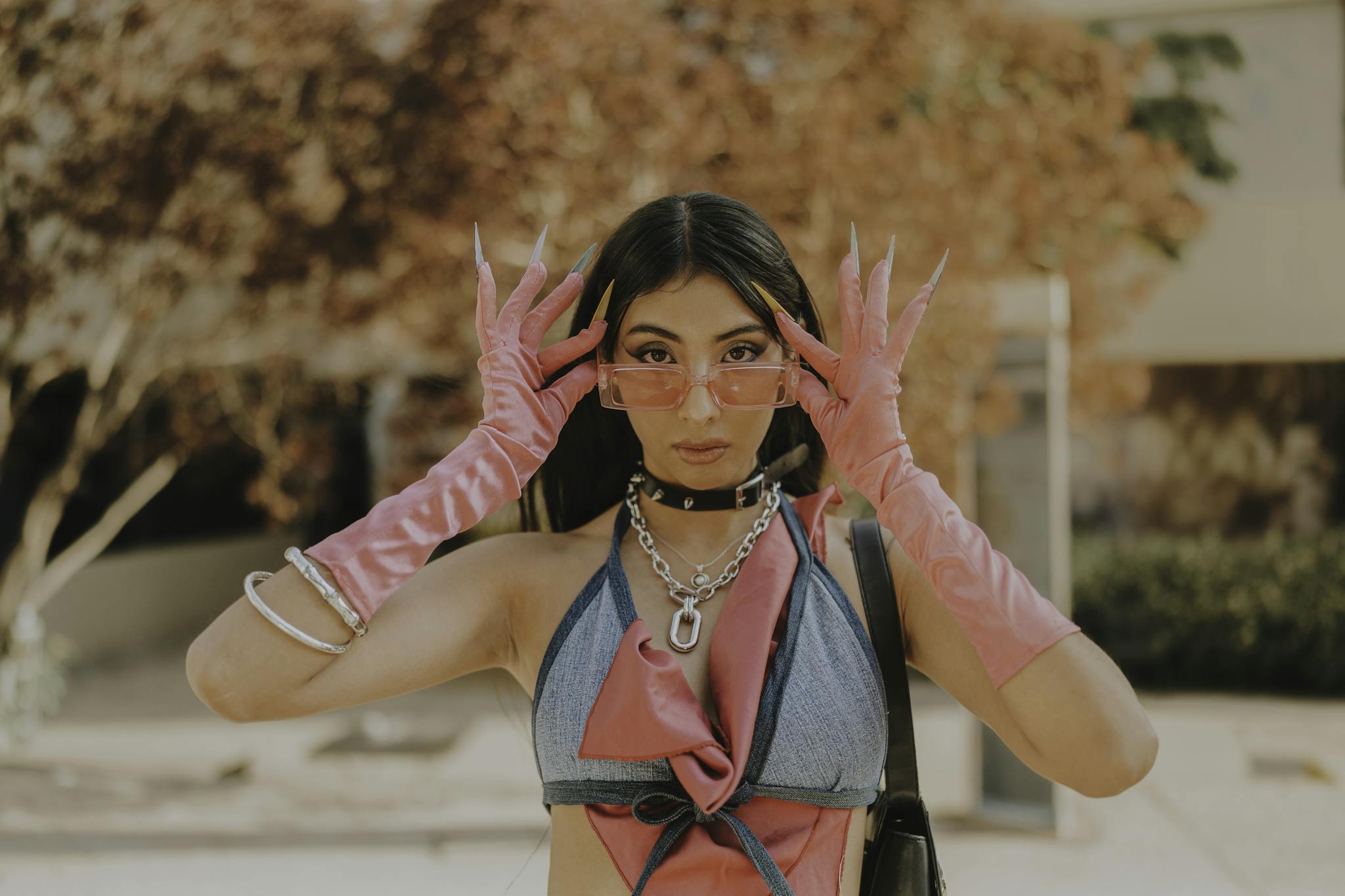 Fashionable woman outdoors in pink gloves and sunglasses capturing a bold style statement.