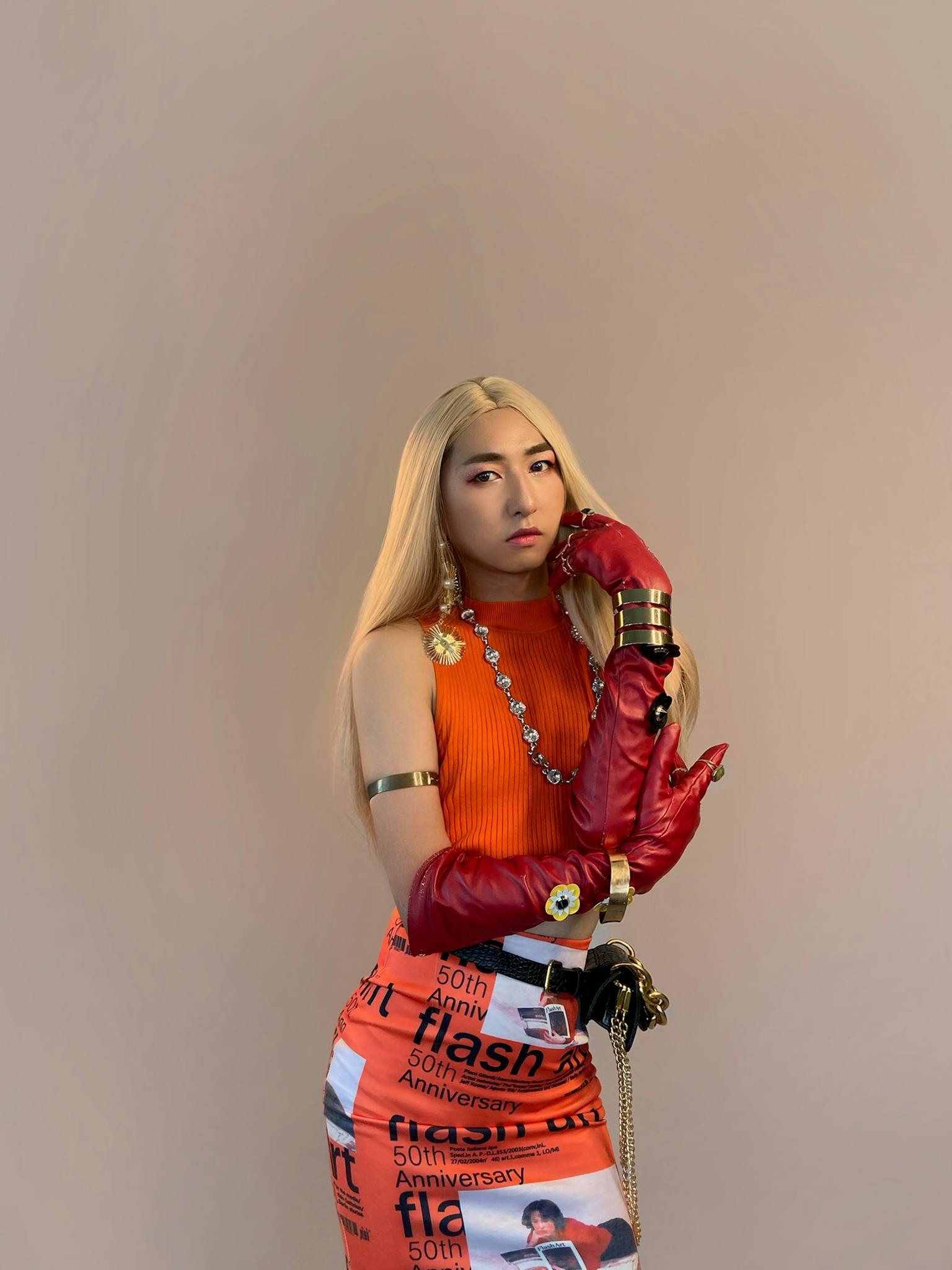 Stylish woman poses confidently in vibrant attire during studio shoot.
